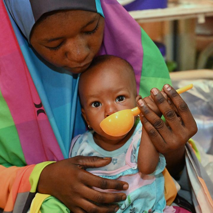Eine Mutter füttert ihr Kind. | © UNICEF/Dejongh