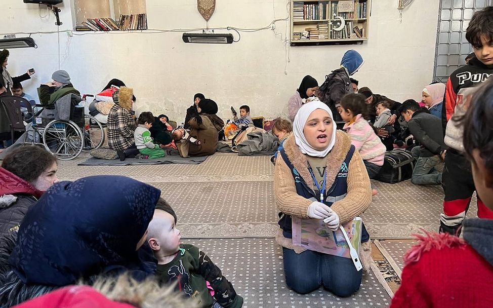Erdbeben Syrien: Gesundheitshelferin spricht mit Familien in Notunterkunft.