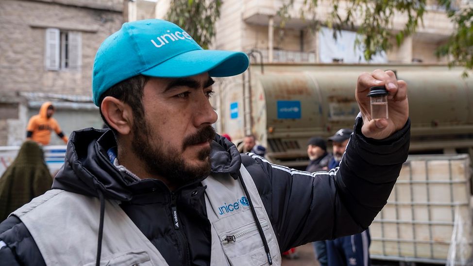 Erdbeben in Syrien: Wasserexperte von UNICEF prüft Trinkwasser in kleinem Glas.