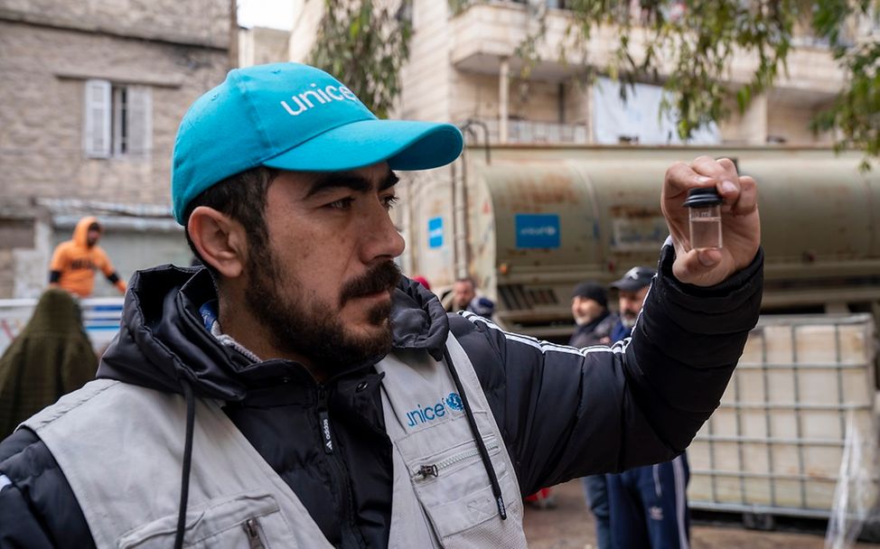 Erdbeben Türkei Syrien: Ein Wasserexperte von UNICEF prüft Trinkwasser in einem kleinen Glas.