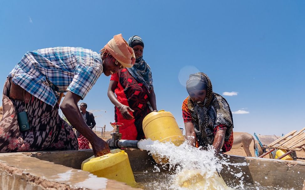 Kenia: Menschen schöpfen Wasser aus einem klimaresistenten Brunnen.