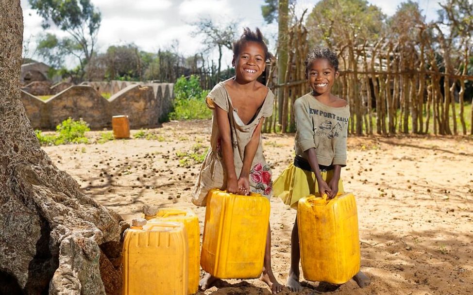 Madagaskar: Kinder mit Wassertanks in den Händen.