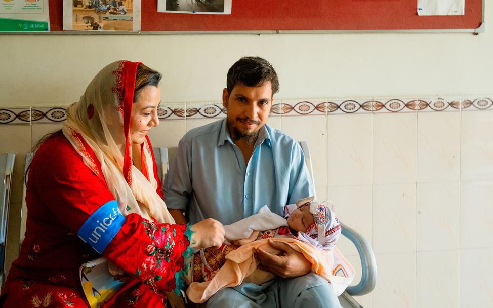 In Karatschi, Pakistan, wird ein Baby von seinem Vater im Warteraum eines Krankenhauses gehalten