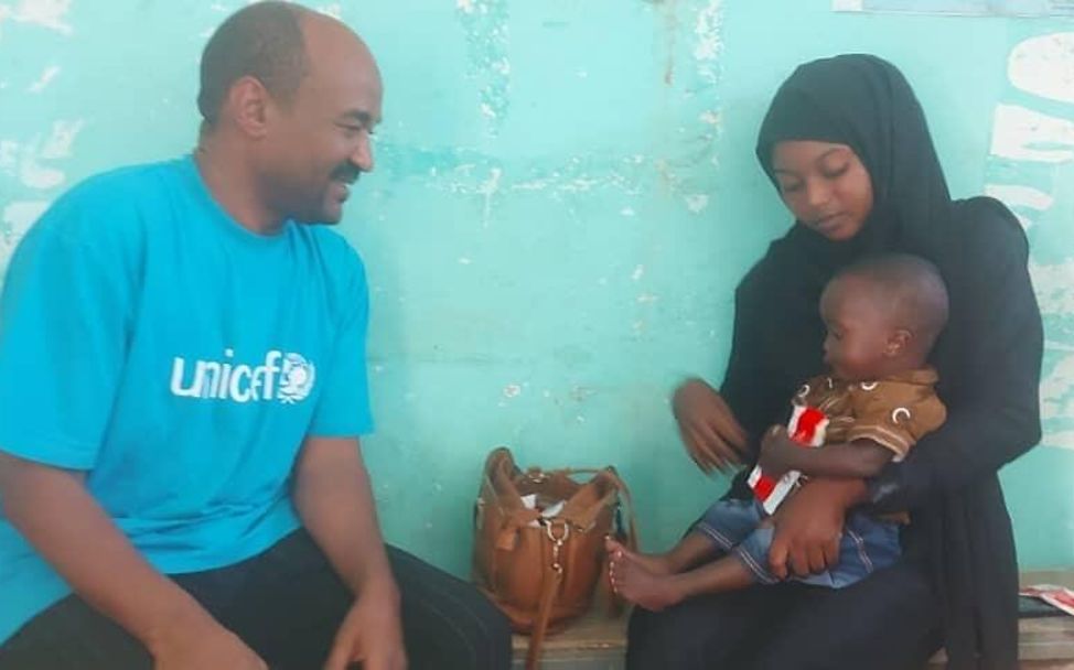 UNICEF Ernährungsspezialist Mohammed Ali Elamin spricht mit einer Mutter
