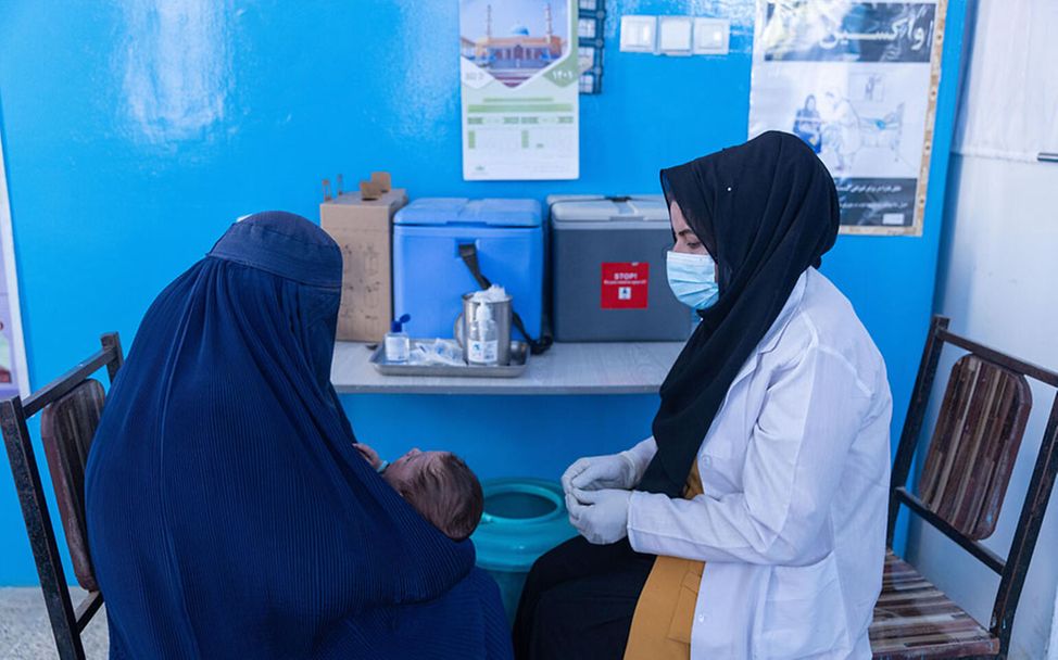 Afghanistan Frauen: Eine Impfhelferin impft ein Baby