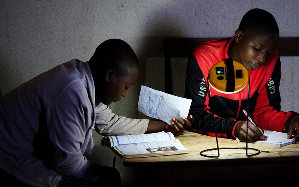 Burundi Licht Innovation: Jugendliche nutzen beim Lernen eine Solarlampe. 