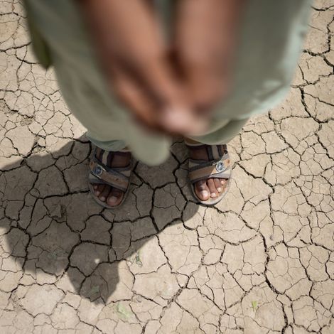 Dürre: Mädchen steht auf trockenem Boden in Pakistan.