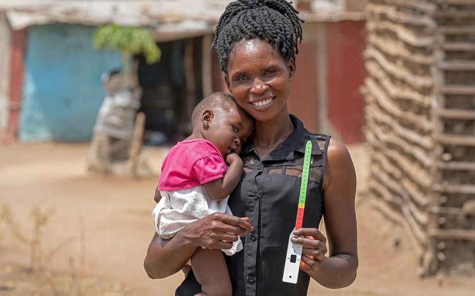 Dürre: Eine Mutter aus dem Südsudan hält ein Maßband in der Hand, mit dem sie überprüfen kann, ob ihr Kinder mangelernährt ist,