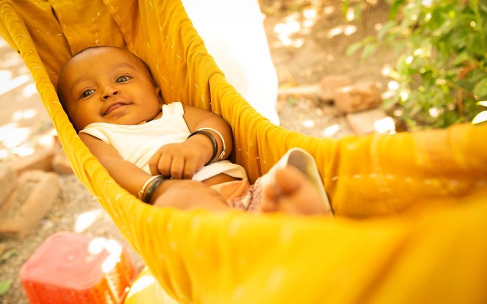 Baby liegt in einer Hängematte zum Schutz vor der Hitze und Sonne