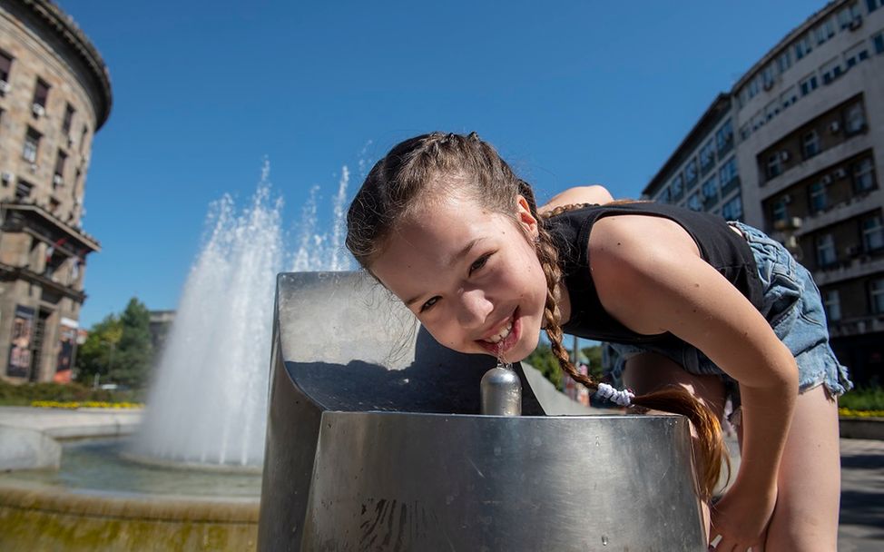 Serbien: Mädchen trinkt an Trinkwasserbrunnen.