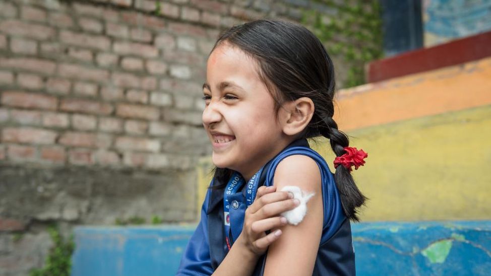 Nepal: Junge hat eine Impfung erhalten und lacht. 