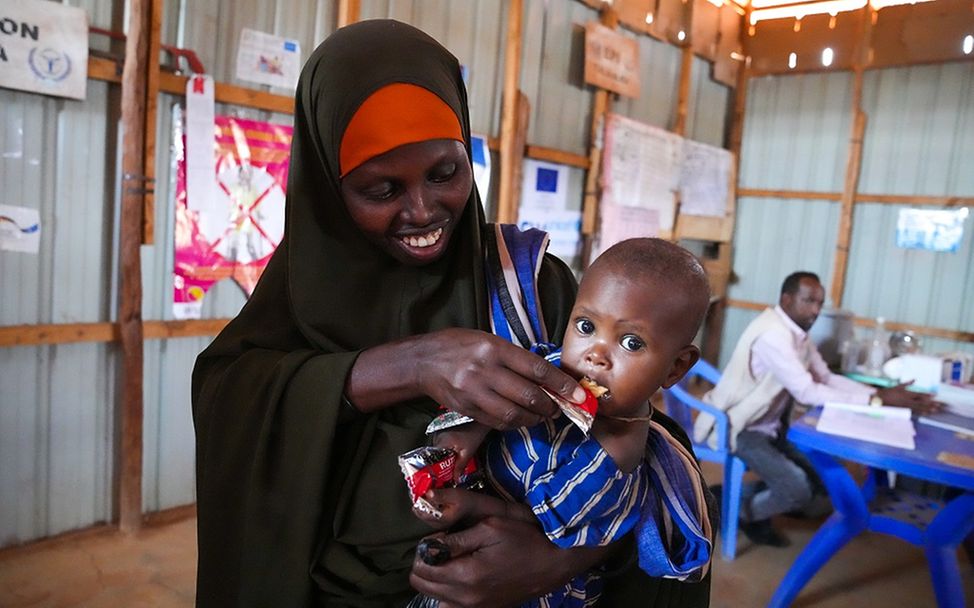 Somalia: Ein Kind auf dem Arm seiner Mutter wird mit Erdnusspaste gefüttert
