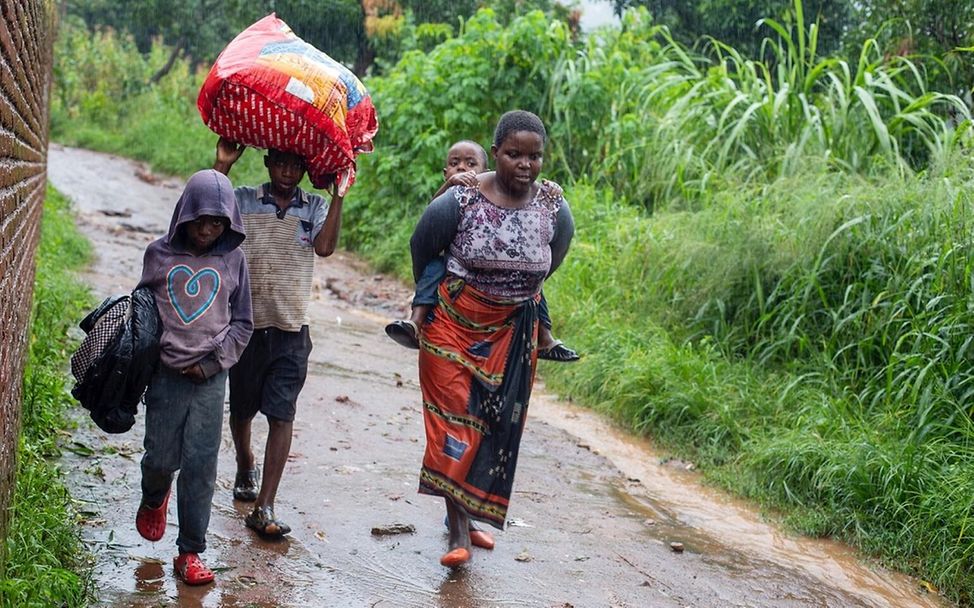 Junge Klimaaktivisten: Eine Familie flieht in Malawi vor den Flogen von Zyklon Freddy.