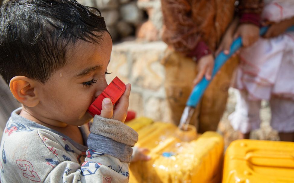 Spenden statt schenken Unternehmen: Ein Junge aus dem Jemen trinkt Wasser