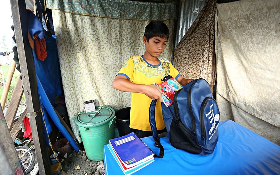 Michel packt seinen Schulrucksack. © UNICEF/NYHQ2014-0032/Joey Reyna