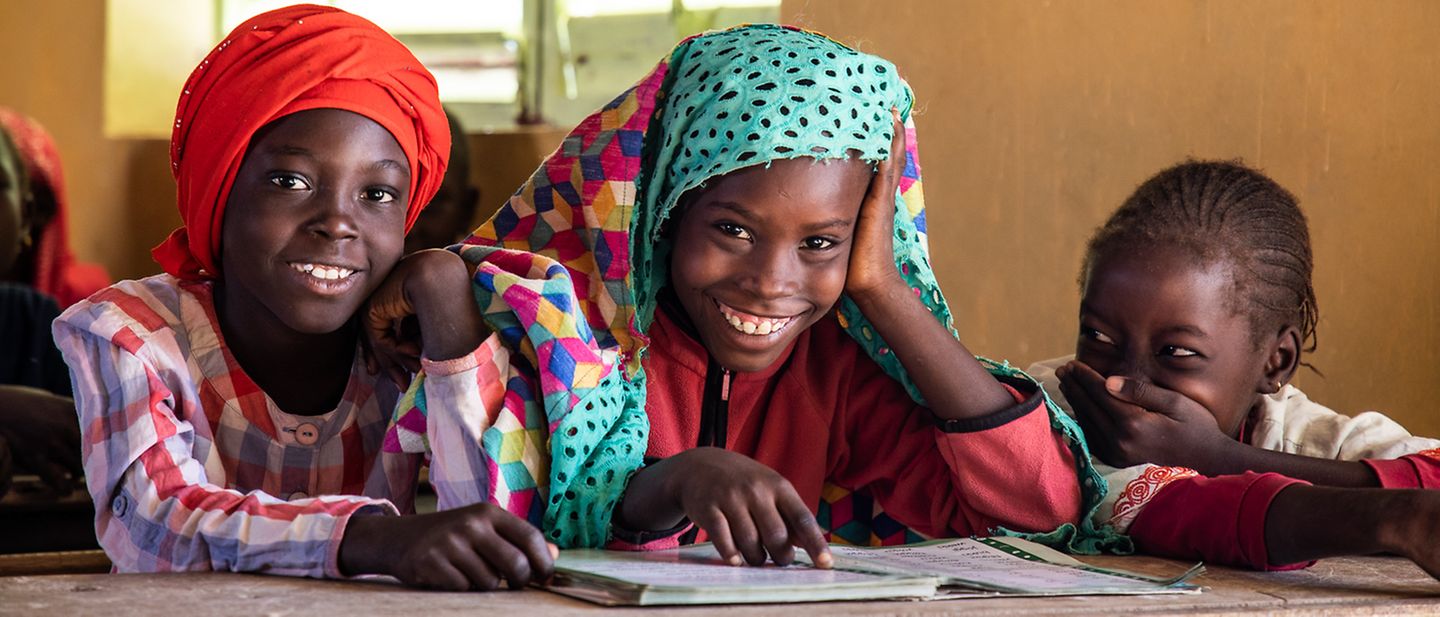 Senegal: Ein Gruppe Schulkinder sitzt im Klassenraum und lacht.