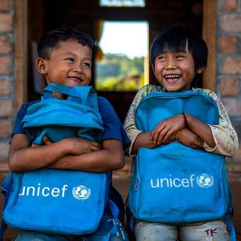 Originelle Geschenkideen: Zwei Schulkinder in Myanmar freuen sich über ihre neuen Rucksäcke von UNICEF