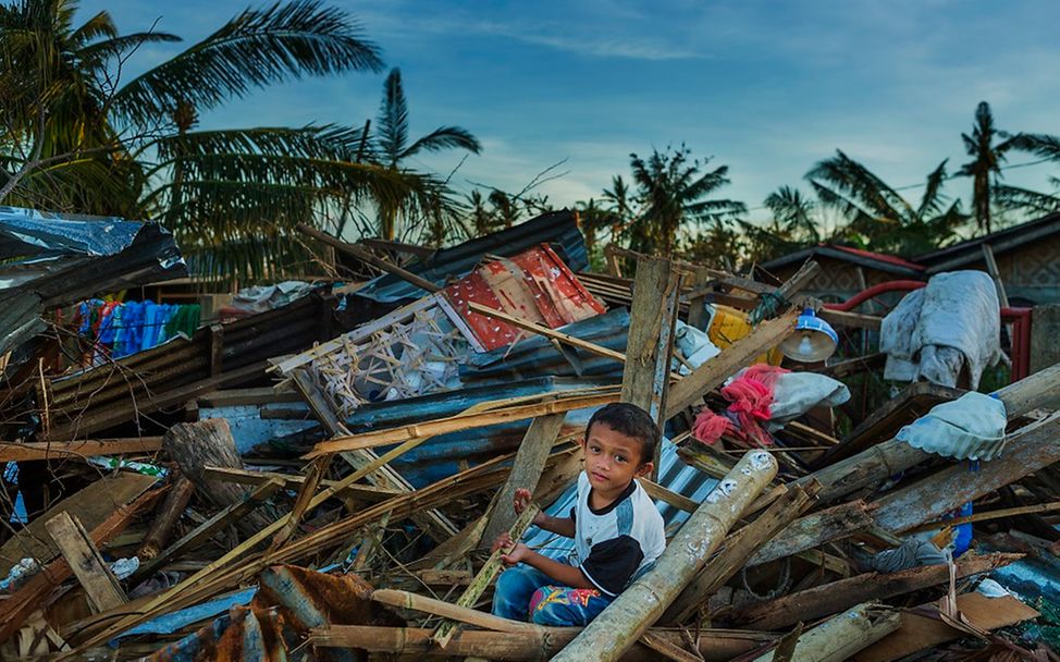Philippinen: Ein Junge sitzt in den Trümmern eines Hauses