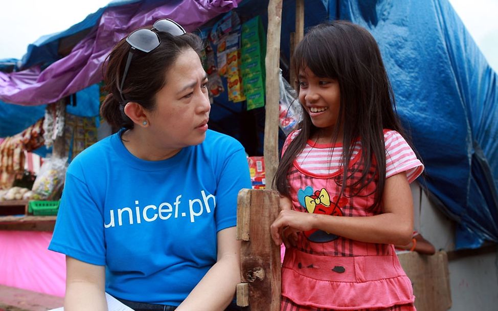 UNICEF-Mitarbeiterin Borromeo mit Cherlyn. © UNICEF Philippinen/Jeoff Maitem