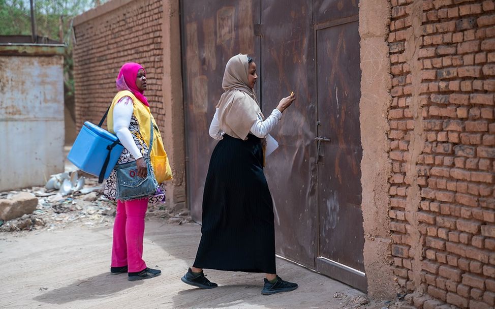 Sudan: Zwei Impfhelferinnen klopfen an einer Tür