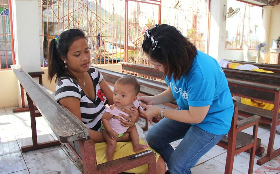 UNICEF-Mitarbeiterin untersucht Jungen auf Mangelernährung. © Louise Lane