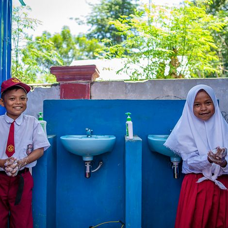 Saputra, 12 und Sisil Agustin, 12 waschen sich die Hände in ihrer Schule in Donggala, Zentralsulawesi, Indonesien.