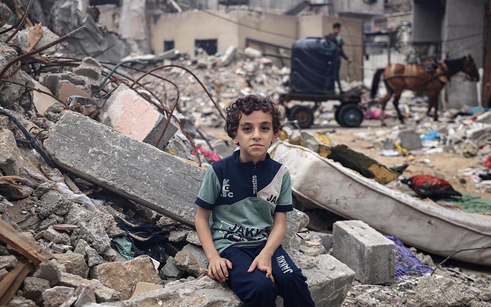 Spenden für Kinder im Gazastreifen: Mohammed sitzt vor den Trümmern seines Zuhauses