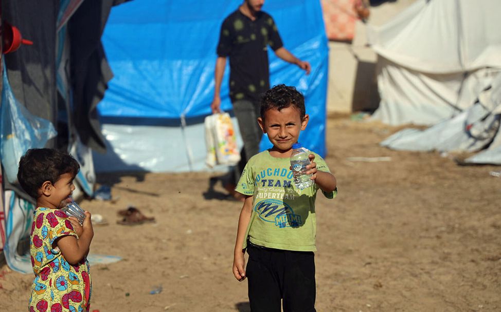 Spenden für Gaza: Ein Junge in einer Flüchtlingsunterkunft hält eine gefüllte Wasserflasche in der Hand. 