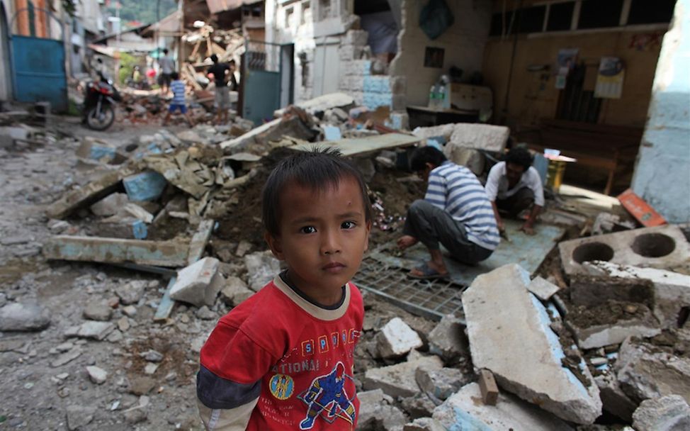 Ein Kind zwischen zerstörten Läden im Zentrum von Padang. © UNICEF/Josh Estey