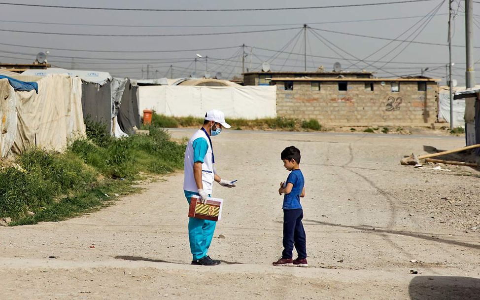 Irak humanitäre Hilfe: Ein UNICEF-Mitarbeiter spricht in einem Flüchtlingscamp mit einem Jungen. 