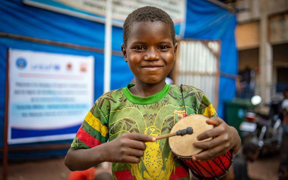 Ein geflüchteter Junge in Mali mit einer Trommel in der Hand. 