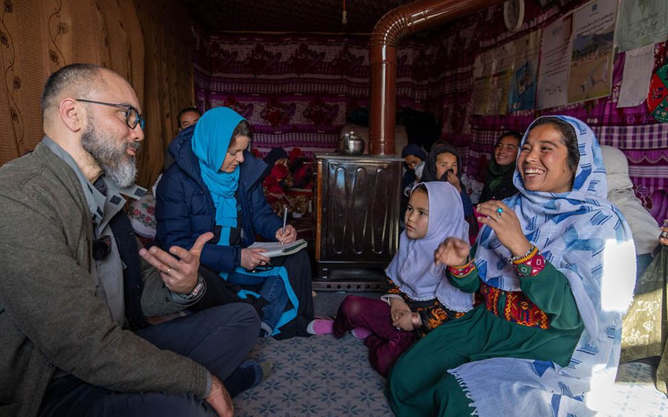 Afghanistan Kinder: UNICEF-Mitarbeitende im Gespräch mit einer afghanischen Familie