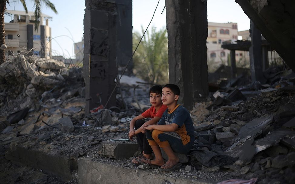 Gaza: Zwei Kinder sitzen in den Trümmern ihres Hauses.
