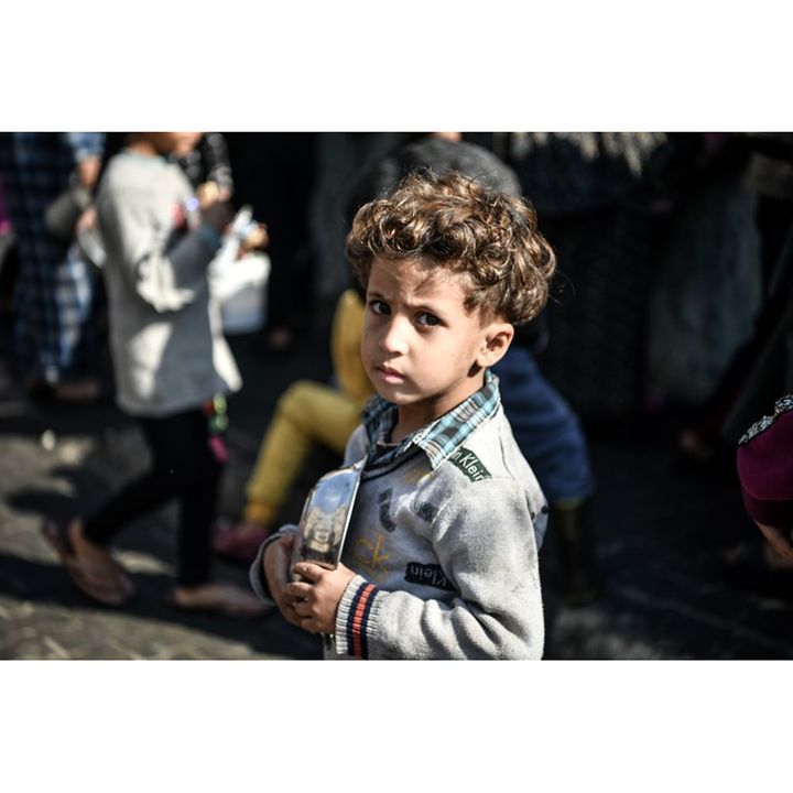 Gaza: Ein erschöpfter Junge hat einen Teller in der Hand.