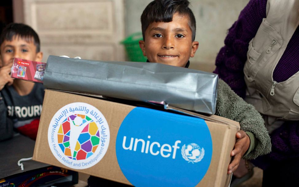 Erdbeben Syrien Türkei: Ein Junge bekommt einen Karton mit UNICEF-Hilfsgütern 