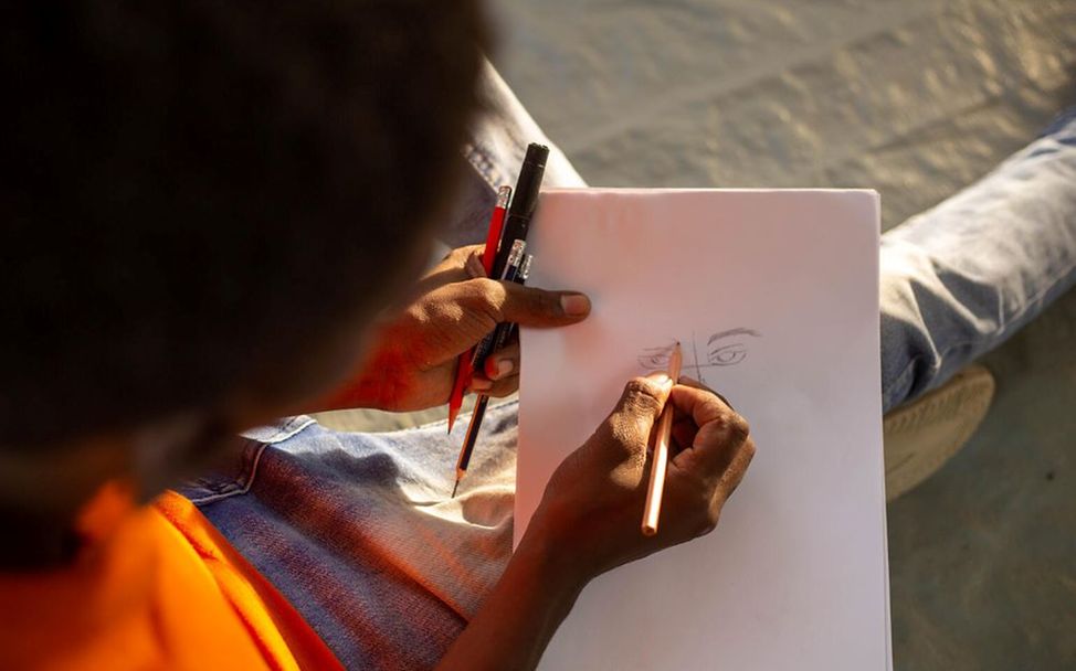 Kinder und Jugendliche im Sudan nehmen an einem Kunst-Workshop teil.