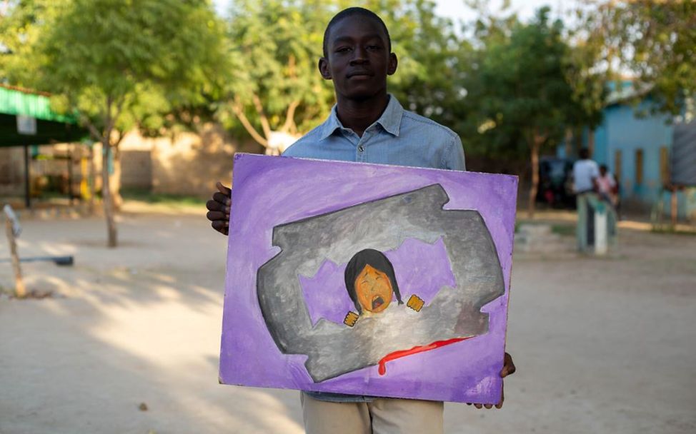 Moataz zeigt sein Bild zur Aufklärung der Folgen der weiblichen Genitalverstümmelung.