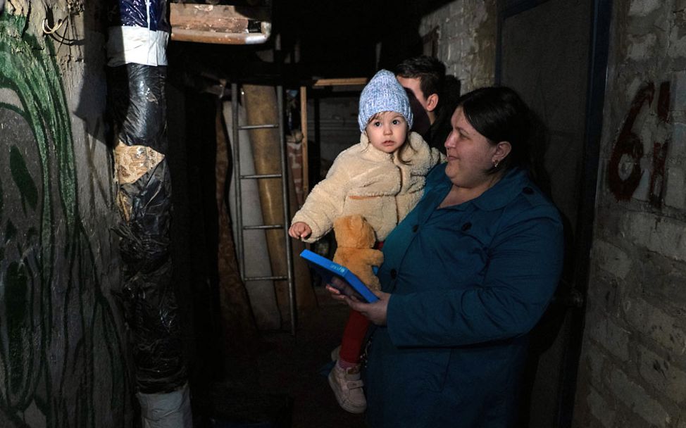 Ukraine Krieg Nothilfe: Ein Kleinkind bei seiner Mutter auf dem Arm in einem Schutzraum in der Ostukraine. 
