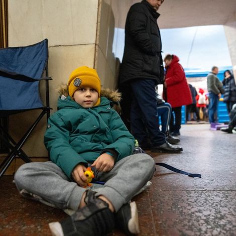 Ukraine: Junge sitzt in U-Bahnstation auf dem Boden. 