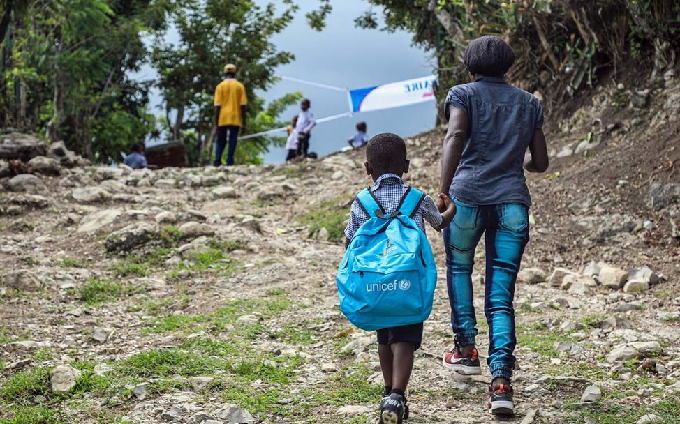Haiti Erdbeben Nothilfe: Eine Mutter geht mit ihrem Sohn an der Hand einen steilen Weg hoch