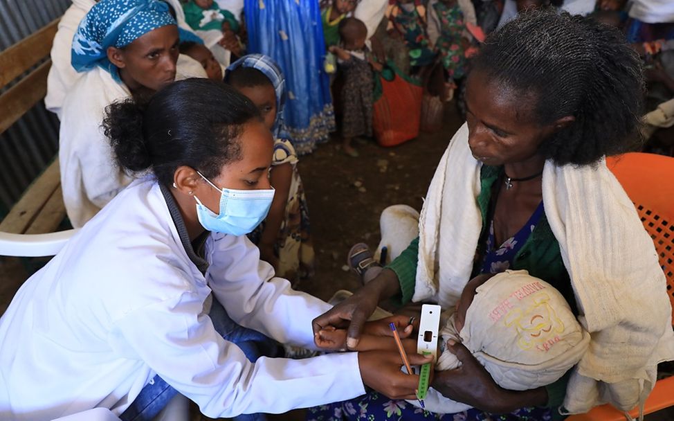 Äthiopien: Eine Gesundheitshelferin untersucht ein Kleinkind auf Mangelernährung. 