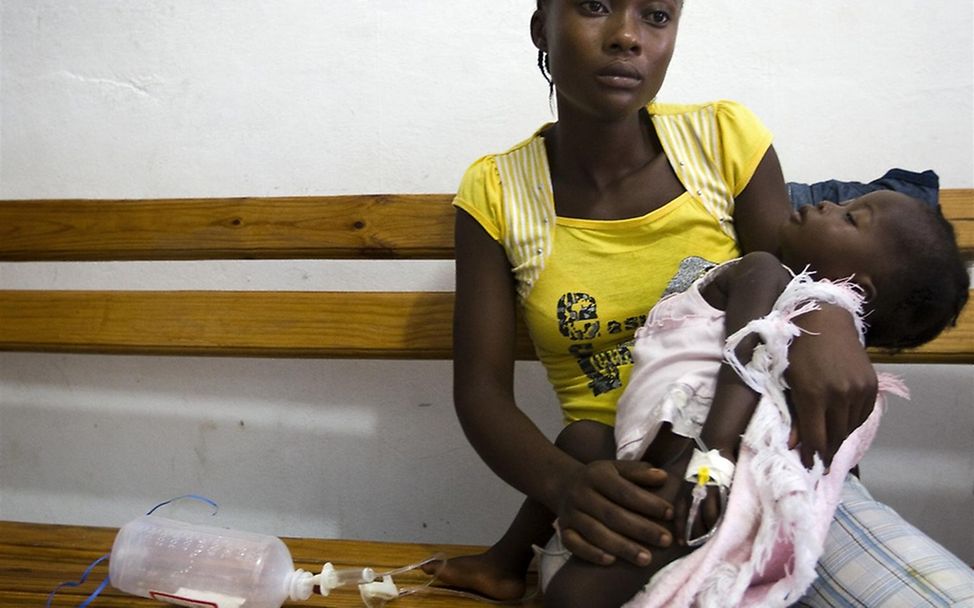 Eine Mutter wartet mit ihrem Kind auf die Behandlung. © UNICEF/Dormino