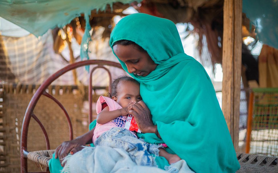 Sudan: Eine Mutter versorgt ihr Kind mit hochwirksamer therapeutischer Nahrung. 
