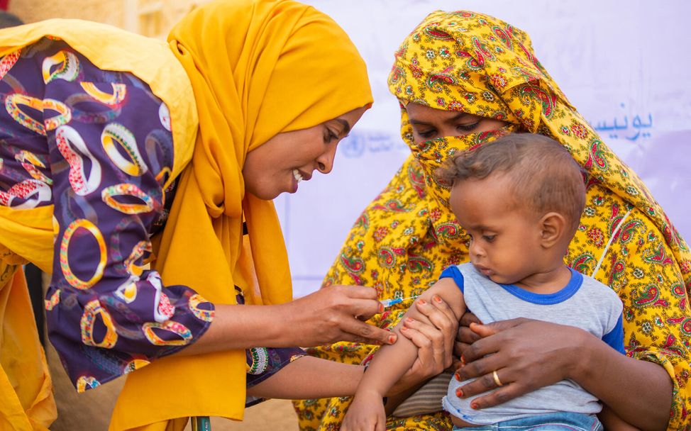 Sudan: Eine Gesundheitshelferin impft beinen Jungen gegen Masern und Röteln 