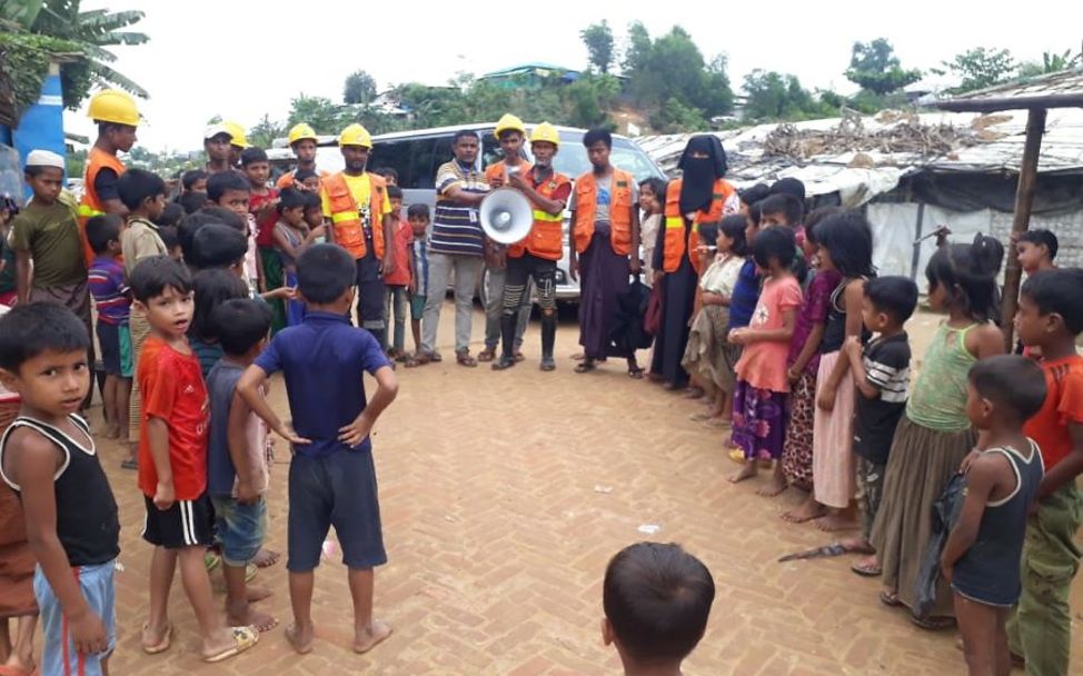Volunteers in Flüchtlingscamp klären Kinder über Stürme auf.