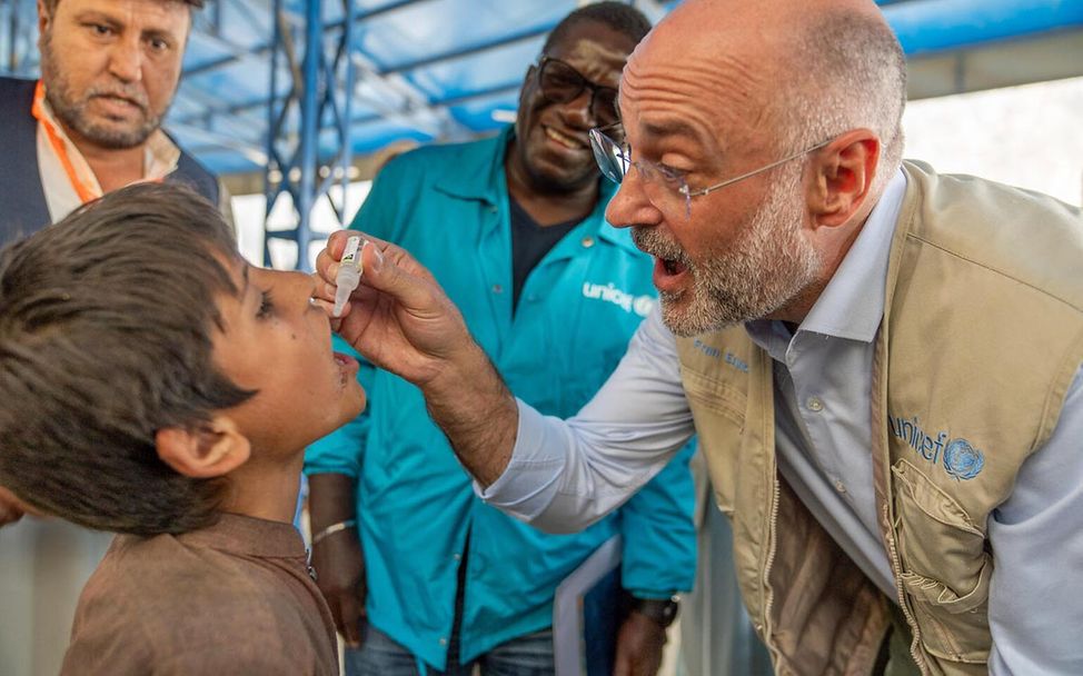 Ausgerottete Krankheiten: Ein UNICEF-Helfer verabreicht einem Jungen in Afghanistan eine Polio-Impfung. 