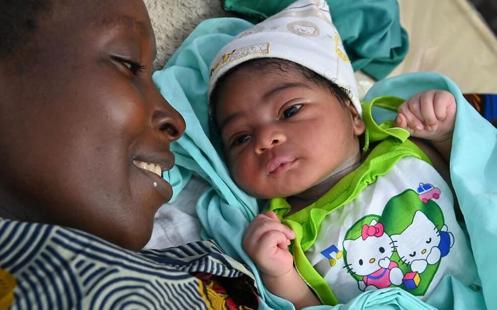 Elfenbeinküste: Eine Mutter kuschelt mit ihrem Baby
