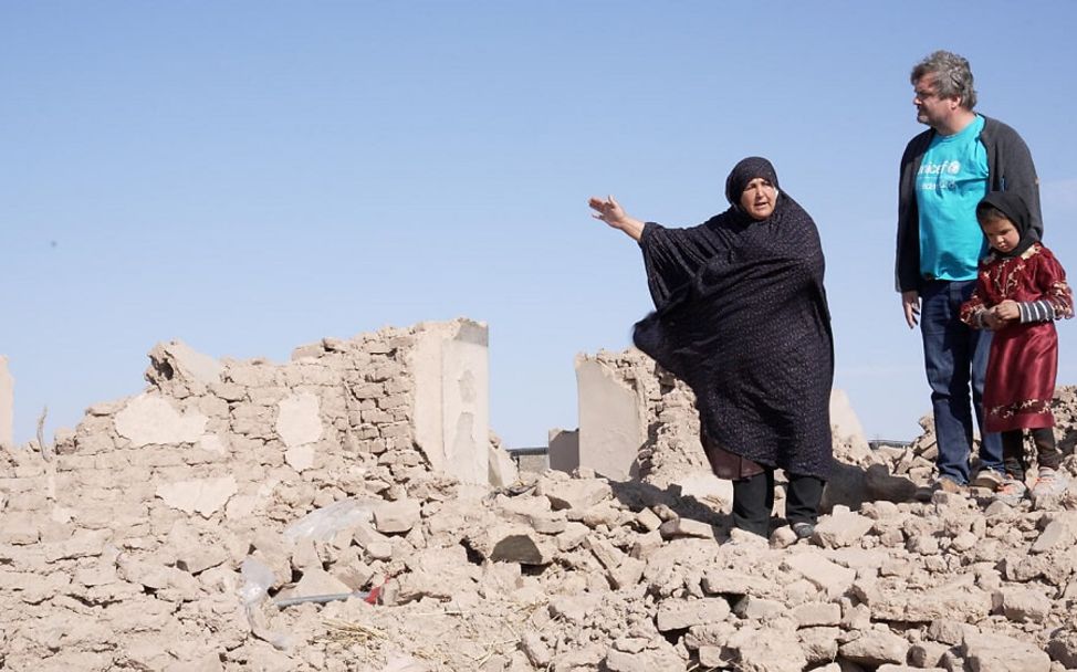 Afghanistan: Eine Frau zeigt nach dem Erdbeben UNICEF-Mitarbeiter Daniel Timme die Trümmer