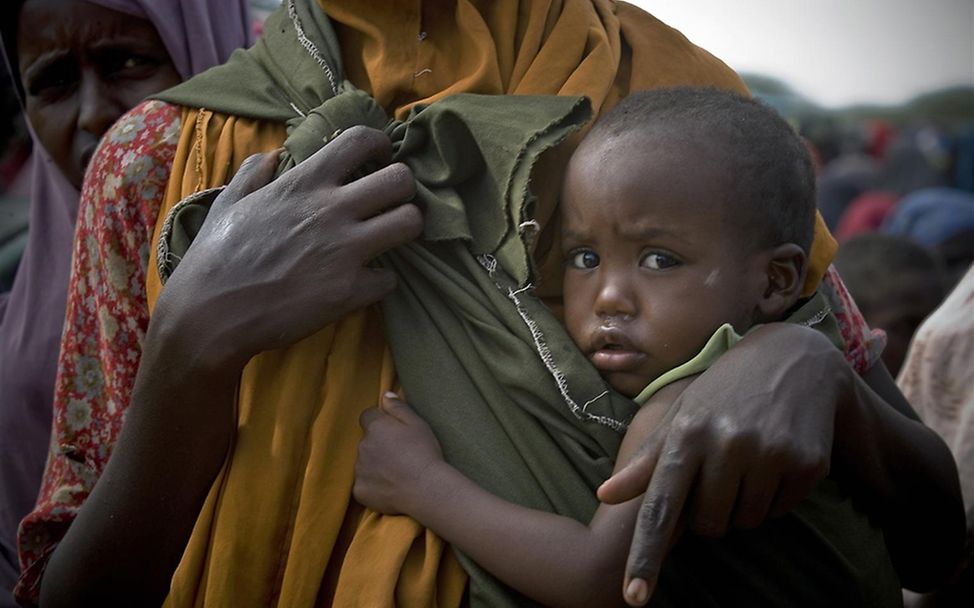 Ein Kind wartet mit seiner Mutter auf die Verteilung von Lebensmitteln. ©UNICEF/Holt