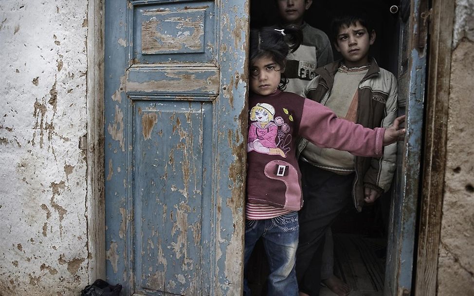 Kinder suchen in einem Türeingang Schutz vor den Gefechten. ©UNICEF/Romenzi